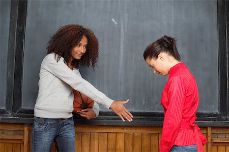 Afro-American woman offering her hand to an Asian woman who is not reacting Stock Photo - Premium Royalty-Free, Code: 628-01278783