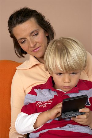 simsearch:628-01279508,k - Son (4-5 Years) playing hand held computer game, mother watching him Stock Photo - Premium Royalty-Free, Code: 628-01278840