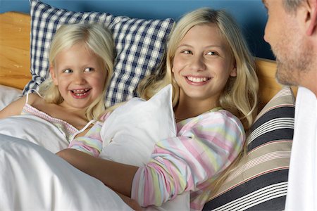 Father at the bed of his two blond daughters, close-up Foto de stock - Sin royalties Premium, Código: 628-01278953