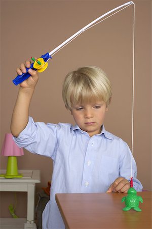 Boy (4-5 Years) using a toy fishing rod Stock Photo - Premium Royalty-Free, Code: 628-01279019