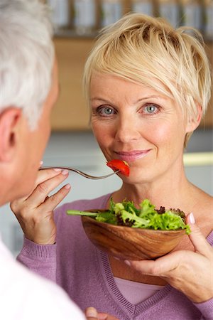 simsearch:628-01279142,k - Blond woman behind a man is eating salad, selective focus, close-up Foto de stock - Royalty Free Premium, Número: 628-01279054