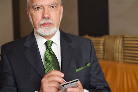 simsearch:628-01278542,k - Mature businessman holding a palmtop Stock Photo - Premium Royalty-Free, Code: 628-01279090