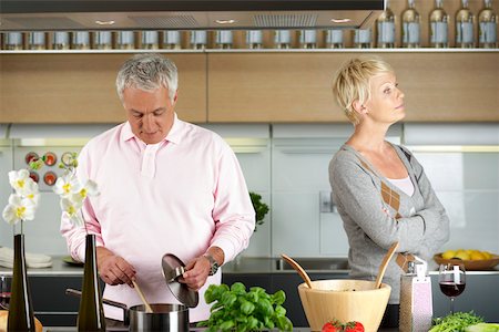Blond woman turned away from a man who is cooking Foto de stock - Sin royalties Premium, Código: 628-01279123