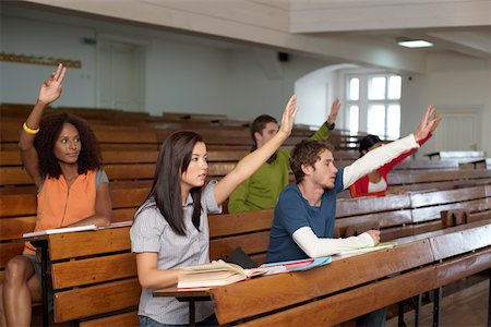 A multi ethnic group in an auditory, each of them raising hand, selective focus Stock Photo - Premium Royalty-Free, Code: 628-01279290