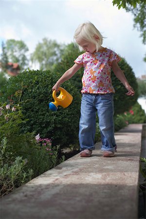 Little blond girl is watering flowers, selective focus Foto de stock - Sin royalties Premium, Código: 628-01279408