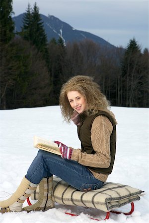 simsearch:628-01495418,k - Young blonde woman with curly hair is sitting on a slide with a book Foto de stock - Sin royalties Premium, Código: 628-01279469