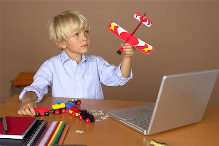 Boy (4-5 Years) playing in the near of a laptop Stock Photo - Premium Royalty-Free, Code: 628-01279493