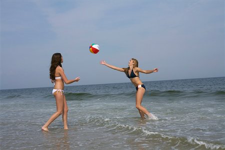 people playing volleyball on the beach - Two young women playing volleyball at the beach Foto de stock - Sin royalties Premium, Código: 628-01279532