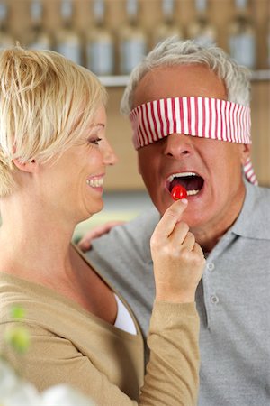 simsearch:628-01279142,k - Blonde woman letting a man, who's eyes are covered, taste a red pepper, close-up Foto de stock - Royalty Free Premium, Número: 628-01279554