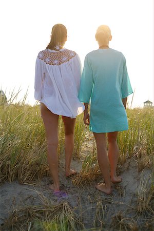 Two young women walking over dunes in the evening sun Stock Photo - Premium Royalty-Free, Code: 628-01279584