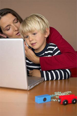 simsearch:628-01279508,k - Mother holding a mobile phone against son's (4-5 Years) ear while using a laptop Stock Photo - Premium Royalty-Free, Code: 628-01279616