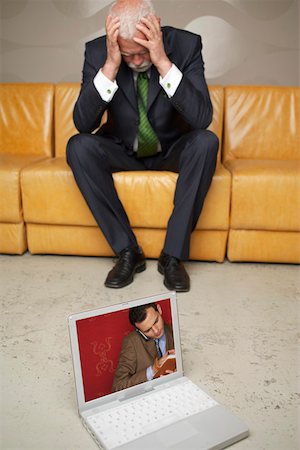 Despaired mature businessman sitting on sofa, laptop standing on floor Foto de stock - Sin royalties Premium, Código: 628-01279623