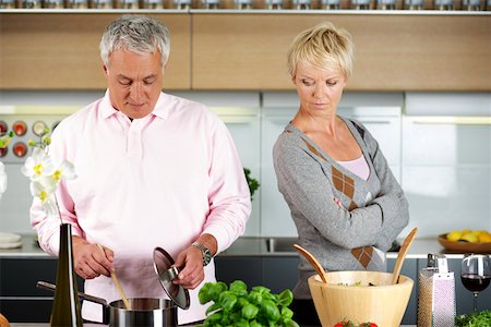Blond woman turned away from a man who is cooking Foto de stock - Sin royalties Premium, Código: 628-01279705