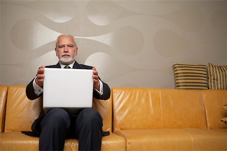 simsearch:628-01278542,k - Mature businessman sitting on a sofa using a laptop Stock Photo - Premium Royalty-Free, Code: 628-01279736