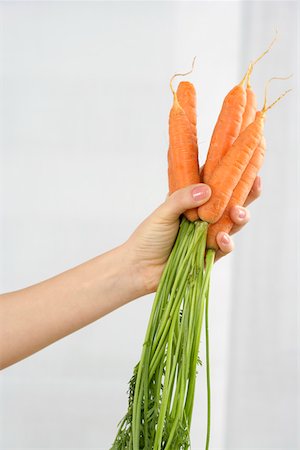 Woman holding carrots Stock Photo - Premium Royalty-Free, Code: 628-01494788