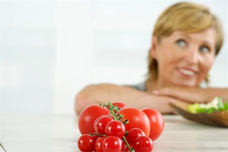 simsearch:628-01495397,k - Haute femme recherchant, tomates au premier plan Photographie de stock - Premium Libres de Droits, Code: 628-01494847