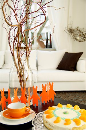 Cake next to a the silhouette of Easter bunnies in a living room, selective focus Stock Photo - Premium Royalty-Free, Code: 628-01494954