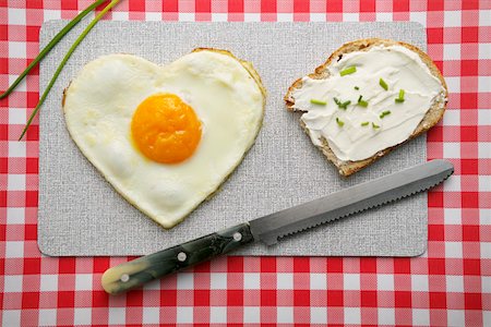 Heart-shaped fried egg and a bread with cream cheese Fotografie stock - Premium Royalty-Free, Codice: 628-01495104
