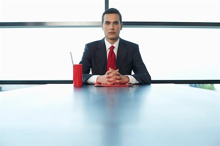 Businessman sitting at a table, portrait Stock Photo - Premium Royalty-Free, Code: 628-01495120