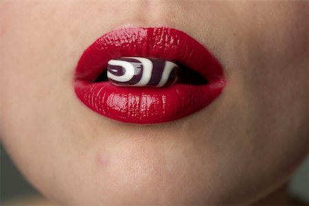 eat mouth closeup - Candy between female red lips Stock Photo - Premium Royalty-Free, Code: 628-01495214