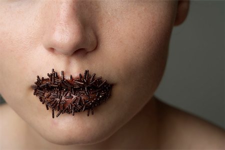 Jeune femme avec des granulés de chocolat sur lui les lèvres, gros plan Photographie de stock - Premium Libres de Droits, Code: 628-01495226