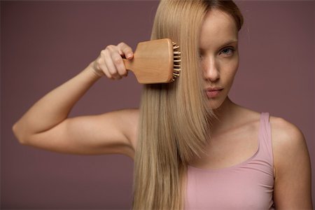straight hair brushing - Young blonde woman brushing her hair, close-up Foto de stock - Sin royalties Premium, Código: 628-01495241