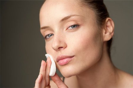 Young woman removing makeup with a cotton pad, close-up Stock Photo - Premium Royalty-Free, Code: 628-01495260