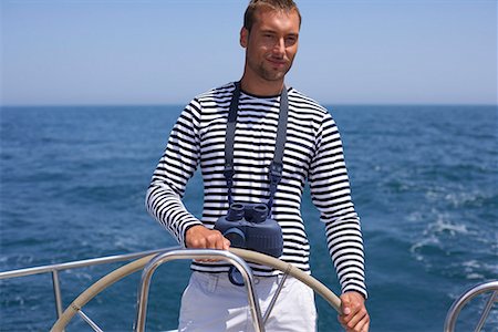 sailing yacht steering wheel - Man steering a Boat Stock Photo - Premium Royalty-Free, Code: 628-01495447