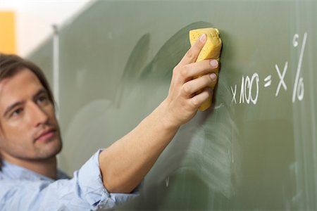 erasing numbers - A man is smearing the board Stock Photo - Premium Royalty-Free, Code: 628-01586674