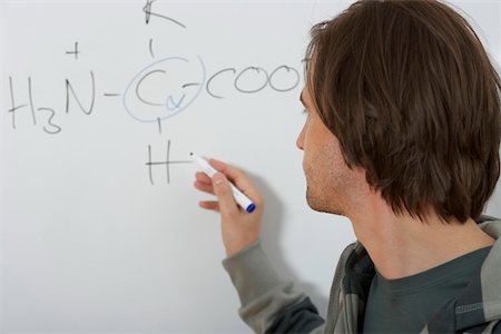 Man is writing prims on a board Stock Photo - Premium Royalty-Free, Code: 628-01586705
