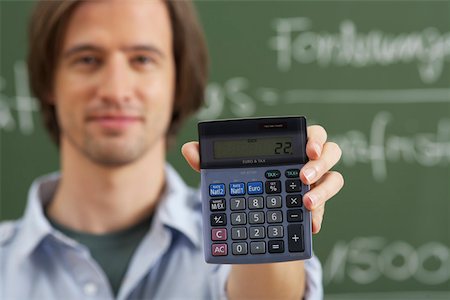 Un homme tient une calculatrice à la main Photographie de stock - Premium Libres de Droits, Code: 628-01586700