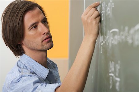 Man is writing prims on a board Stock Photo - Premium Royalty-Free, Code: 628-01586726