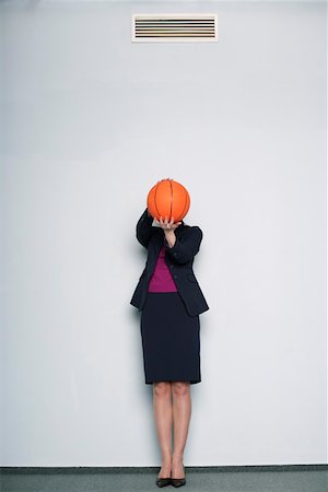 Businesswoman covering face with a basketball Stock Photo - Premium Royalty-Free, Code: 628-01639065