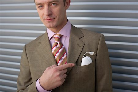 Businessman pointing at computer mouse in pocket Stock Photo - Premium Royalty-Free, Code: 628-01639060