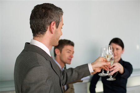 simsearch:628-01639098,k - Three businesspeople clinking glasses Stock Photo - Premium Royalty-Free, Code: 628-01639097