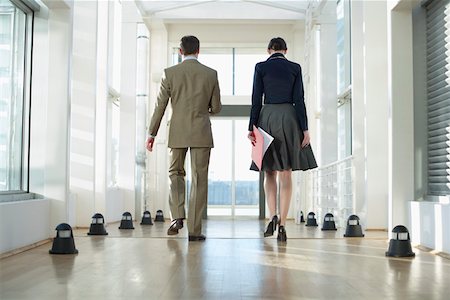 simsearch:628-01639098,k - Two businesspeople walking over corridor Stock Photo - Premium Royalty-Free, Code: 628-01639125