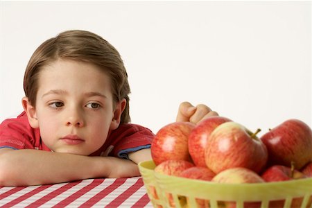 Boy sitting beside a few apples Stock Photo - Premium Royalty-Free, Code: 628-01711944