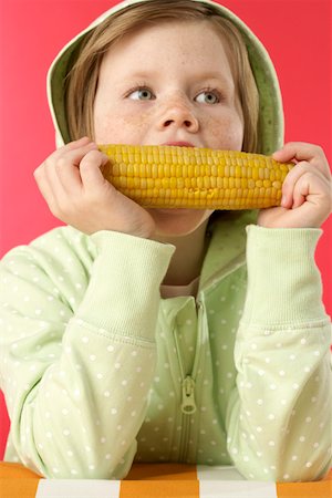 Girl eating a corncob Foto de stock - Sin royalties Premium, Código: 628-01711951