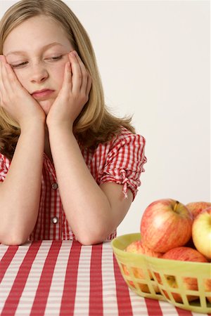 reject food - Girl sitting in front of some apples Stock Photo - Premium Royalty-Free, Code: 628-01711953
