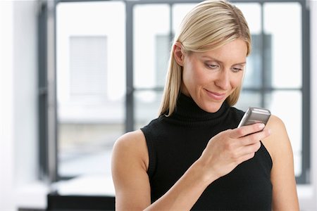 Young woman holding a mobile phone Stock Photo - Premium Royalty-Free, Code: 628-01712041