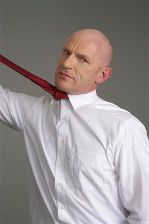 Businessman pulling his tie Stock Photo - Premium Royalty-Free, Code: 628-01712112