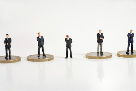 simsearch:628-01712237,k - Businessman figurine between other ones standing on coins Foto de stock - Royalty Free Premium, Número: 628-01712328