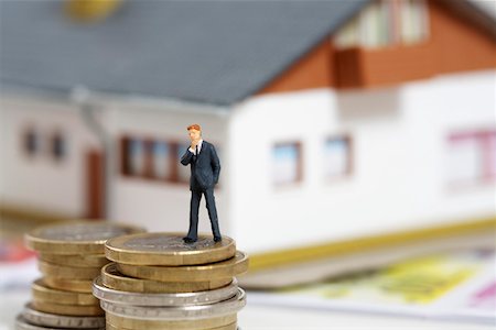 simsearch:628-01712237,k - Businessman figurine on a stack of coins, miniature house in background Foto de stock - Royalty Free Premium, Número: 628-01712333