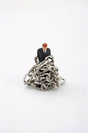 Businessman figurine tied up with a chain Stock Photo - Premium Royalty-Free, Code: 628-01712341