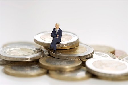 simsearch:628-01712237,k - Businessman figurine sitting on heap of coins Foto de stock - Royalty Free Premium, Número: 628-01712343