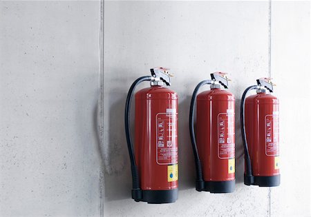 estintore - Three extinguishers at a wall Fotografie stock - Premium Royalty-Free, Codice: 628-02062589