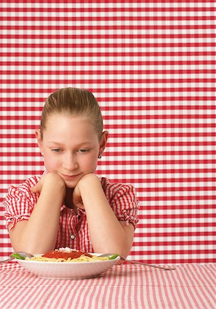 Girl (10-11 years) looking on a plate of spaghetti Stock Photo - Premium Royalty-Free, Code: 628-02062596