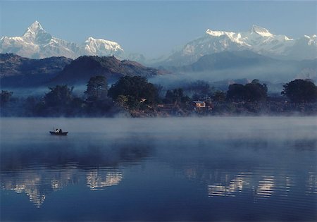 rowboat fog pictures - Fisher on lake in morning fog, Alpine scenery in background Stock Photo - Premium Royalty-Free, Code: 628-02062679
