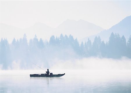 Fisherman on lake in morning mist Stock Photo - Premium Royalty-Free, Code: 628-02062754