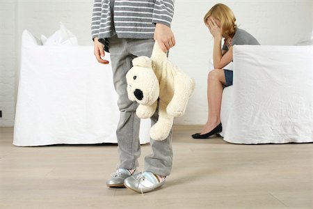 Despaired woman sitting in armchair, girl holding stuffed animal standing in foreground Foto de stock - Sin royalties Premium, Código: 628-02197936